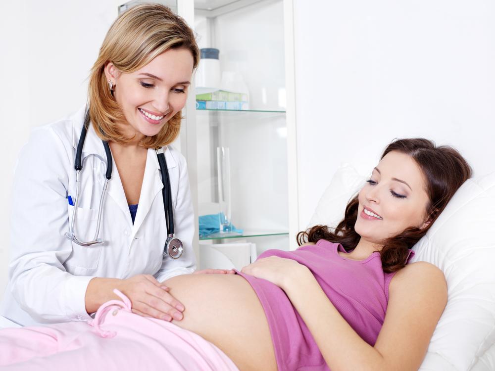 Doctor Care about young pregnant woman in hospital - indoors